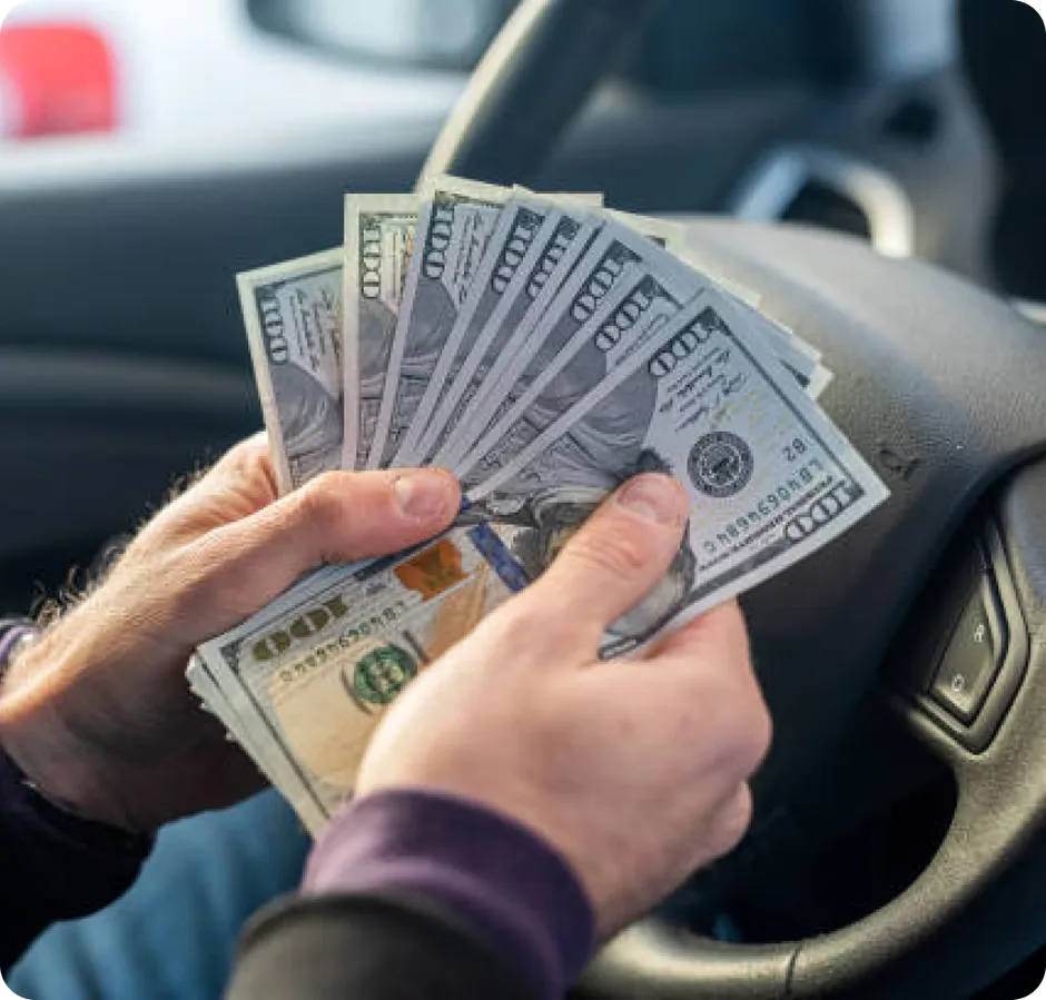 A driver counting rental earnings behind the wheel